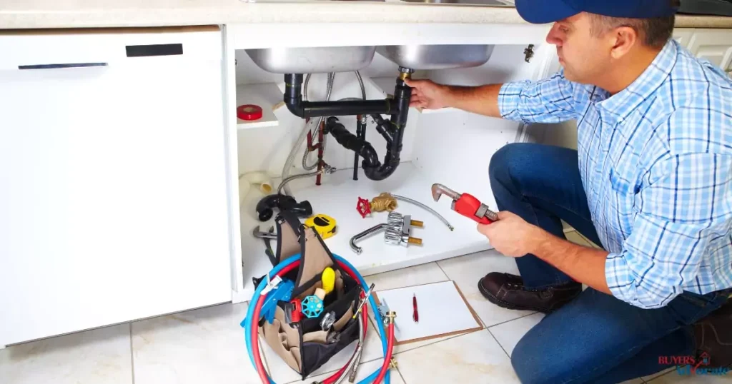 A plumber fixing a sink as part of property maintenance and emergency repair services.