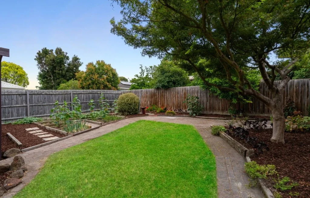 Private backyard with a generous lawn and established vegetable garden on approximately 654m².